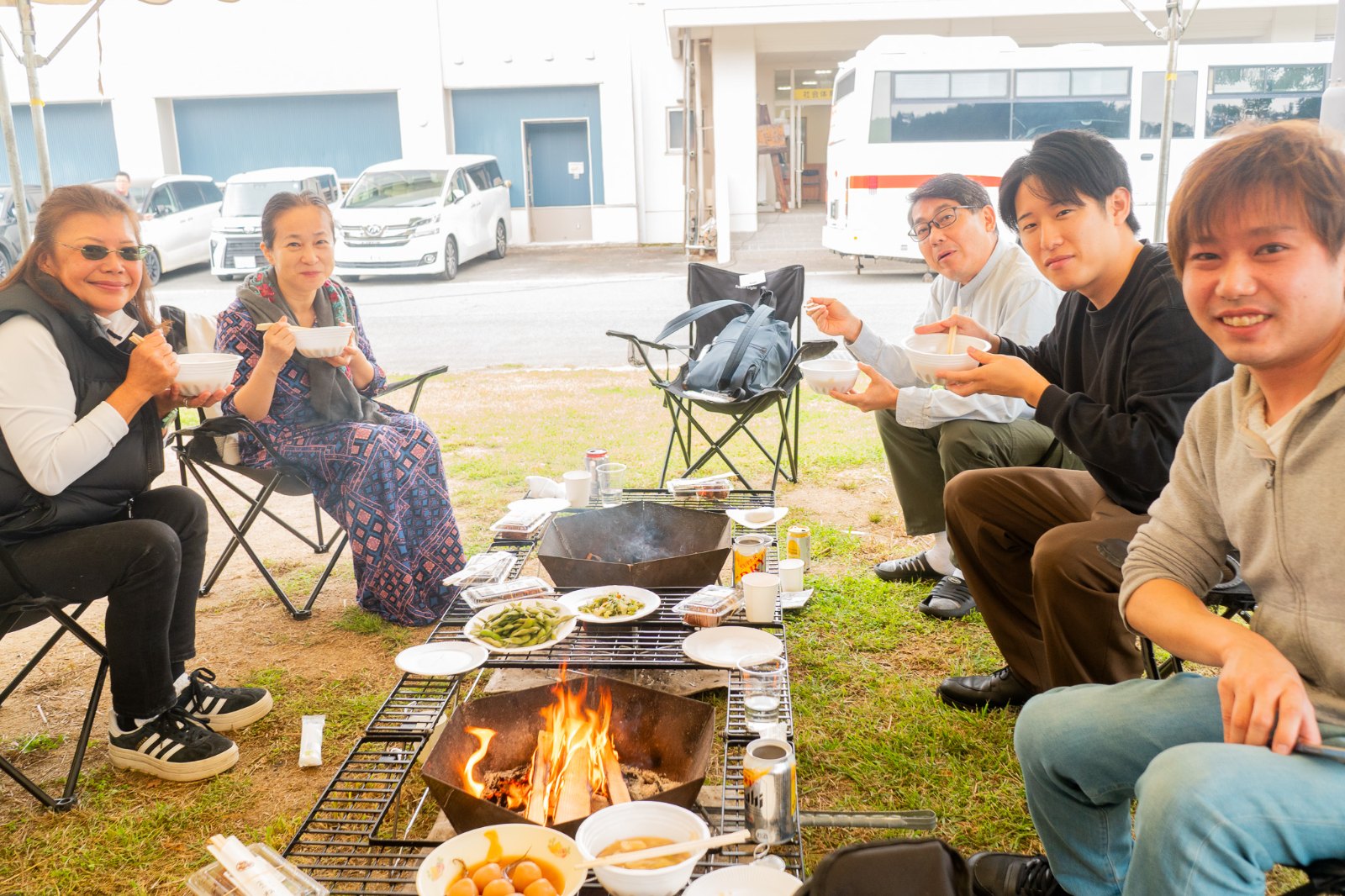 焚き火の前で芋煮を楽しむ参加者